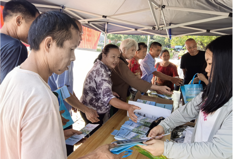 工作人员向群众发放宣传手册.png